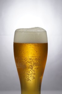 Clear drinking glass with beer and foam