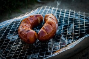 Two sausages on charcoal grill