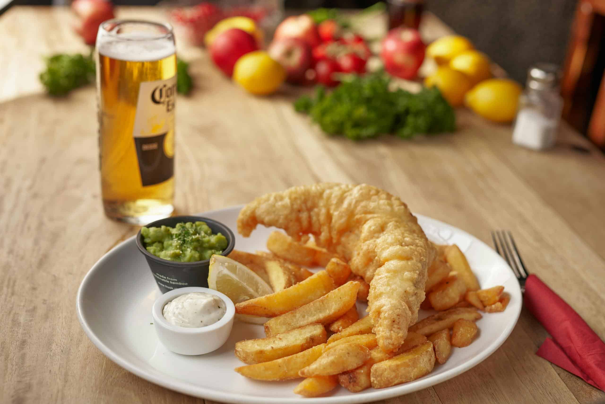 A delicious serving of fish and chips with a refreshing beer, perfect for a casual dining experience.