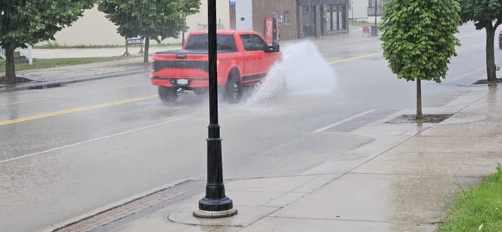Cars splash through shallow floodwater at 11th & Indiana Ave during a 20‑minute summer downpour that overwhelmed storm drains—but receded just as fast when the rain let up.