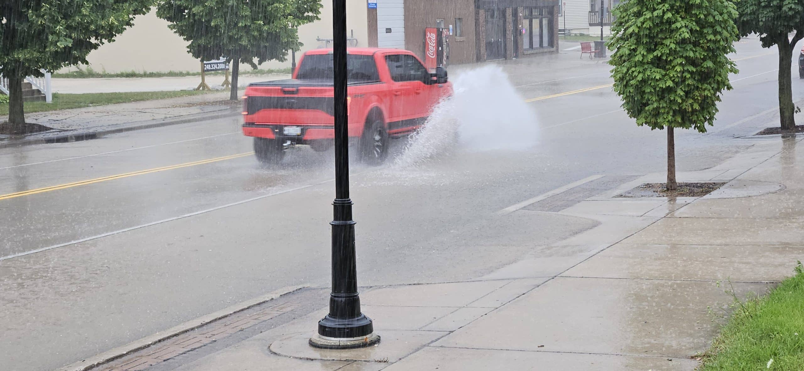 Cars splash through shallow floodwater at 11th & Indiana Ave during a 20‑minute summer downpour that overwhelmed storm drains—but receded just as fast when the rain let up.