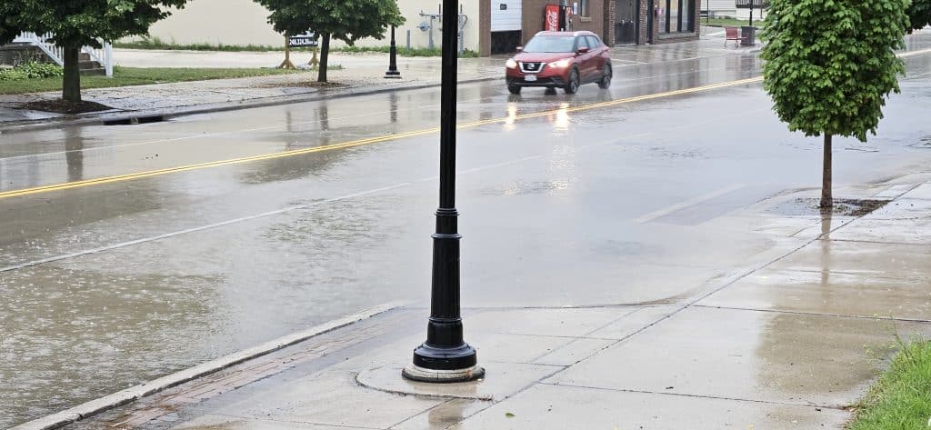 Cars splash through shallow floodwater at 11th & Indiana Ave during a 20‑minute summer downpour that overwhelmed storm drains—but receded just as fast when the rain let up.