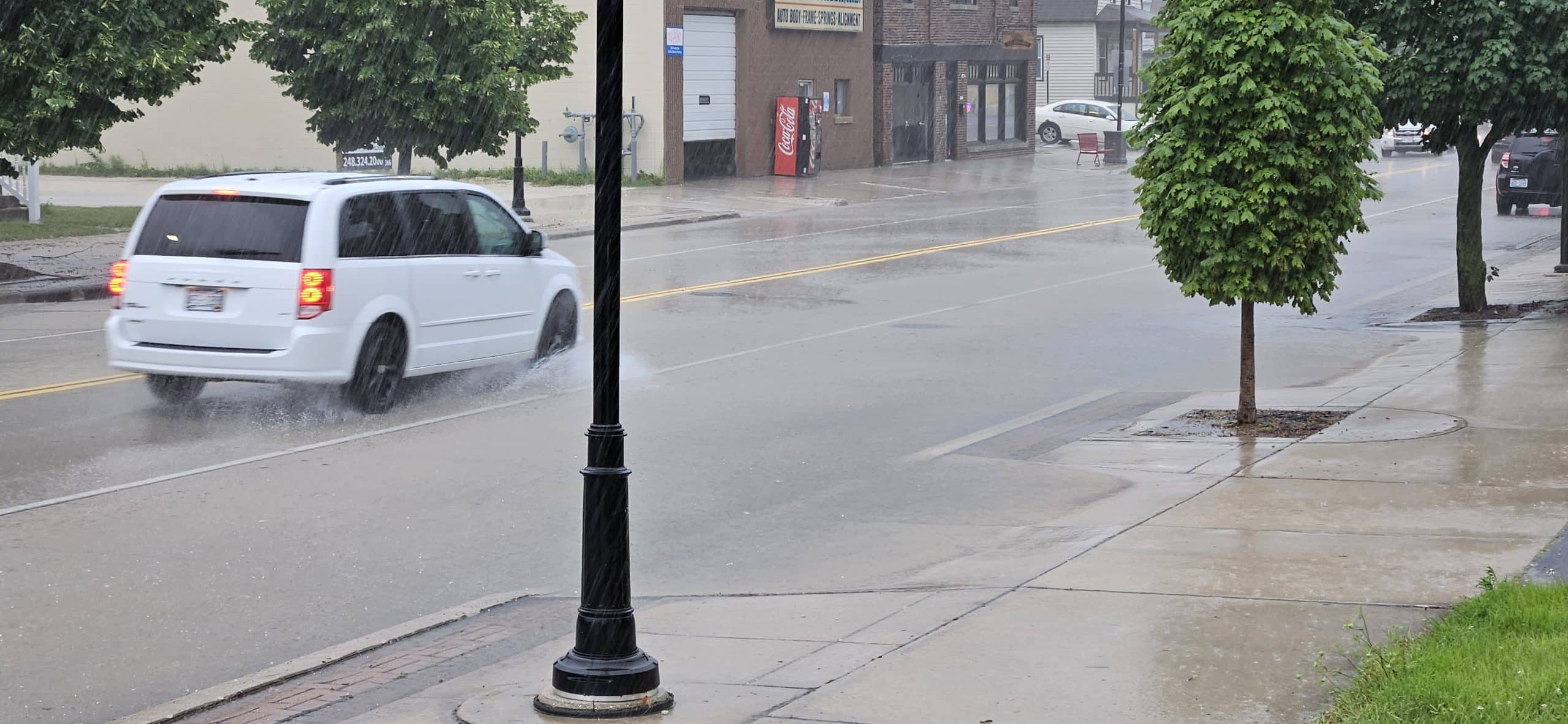 Cars splash through shallow floodwater at 11th & Indiana Ave during a 20‑minute summer downpour that overwhelmed storm drains—but receded just as fast when the rain let up.