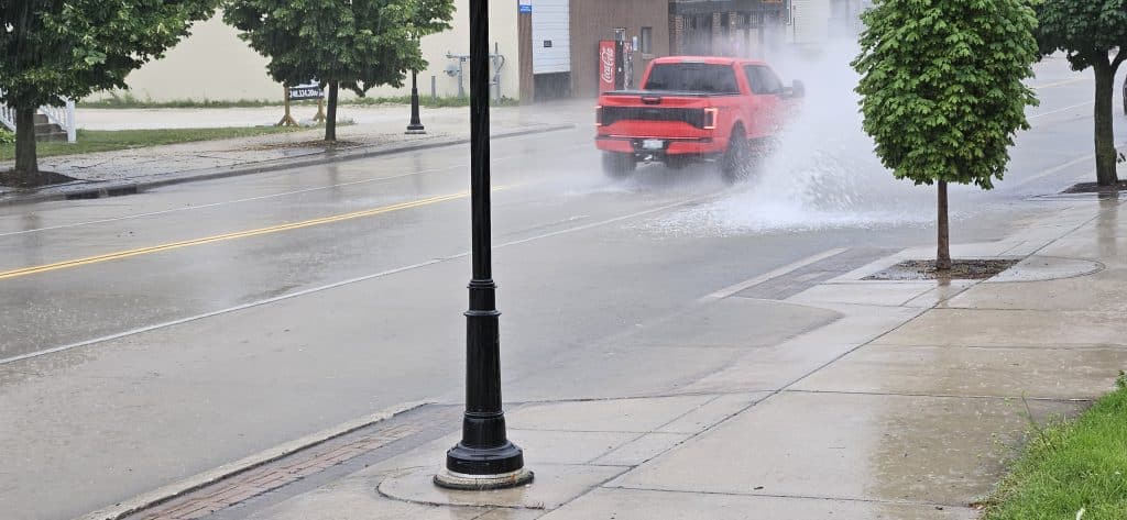 Cars splash through shallow floodwater at 11th & Indiana Ave during a 20‑minute summer downpour that overwhelmed storm drains—but receded just as fast when the rain let up.