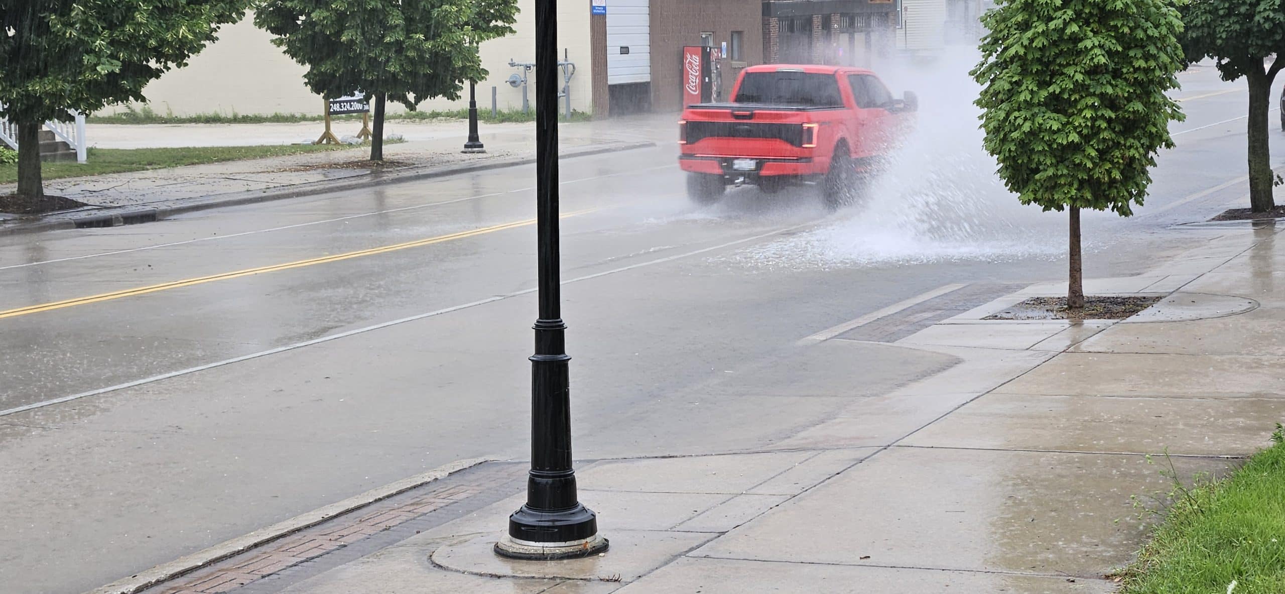 Cars splash through shallow floodwater at 11th & Indiana Ave during a 20‑minute summer downpour that overwhelmed storm drains—but receded just as fast when the rain let up.