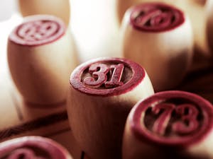 Wooden bingo game chips in focus, displaying numbers 31 and 73.